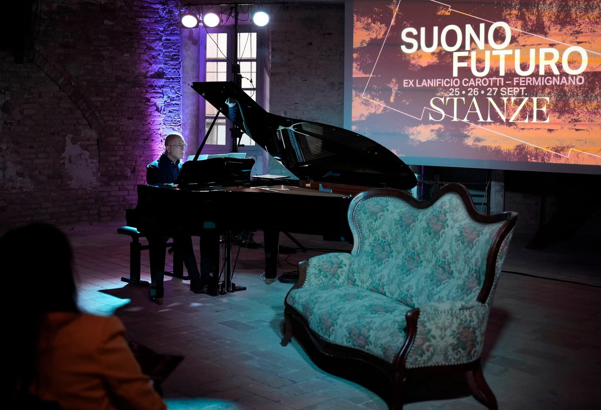 Il pianista durante l'esecuzione, con il divano d'epoca in primo piano